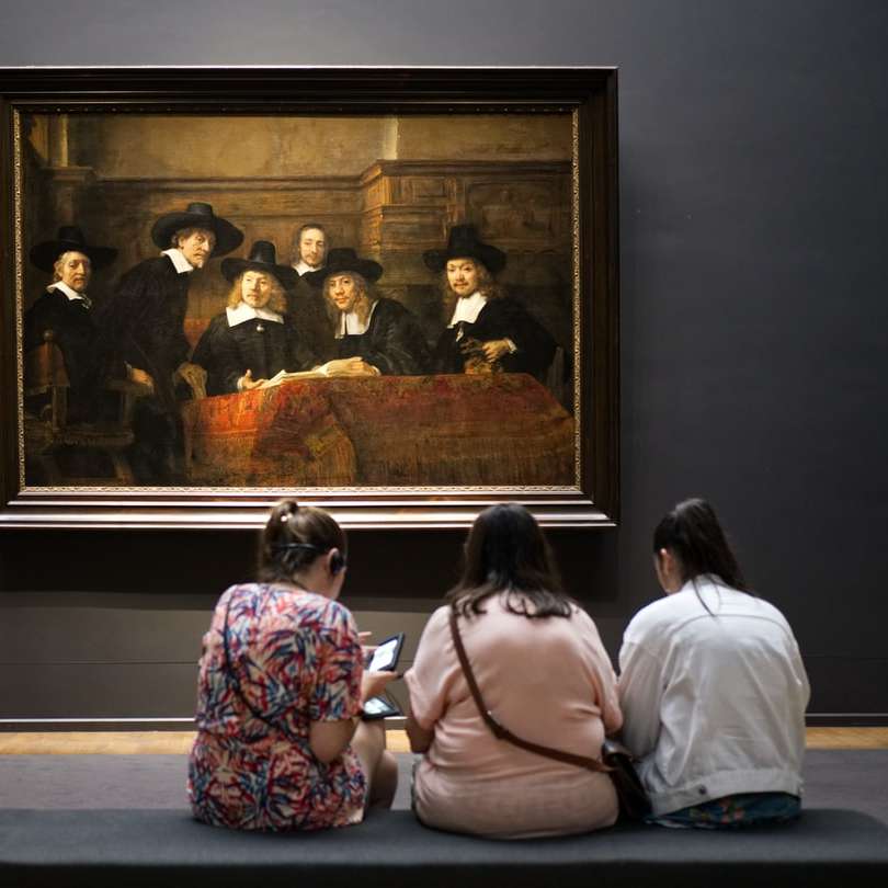 Drei Frauen sitzen auf dem Boden vor einem Gemälde Online-Puzzle