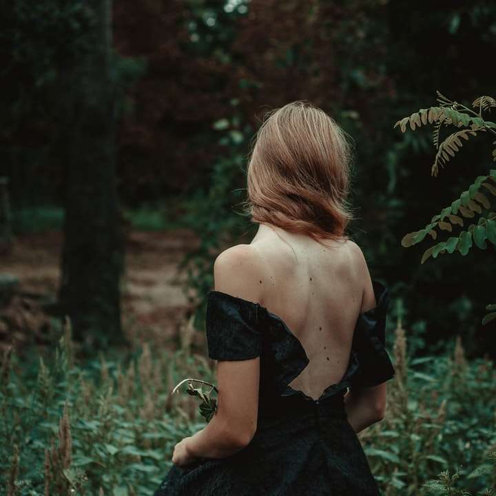 fotografia de foco seletivo de mulher em pé na floresta puzzle deslizante online