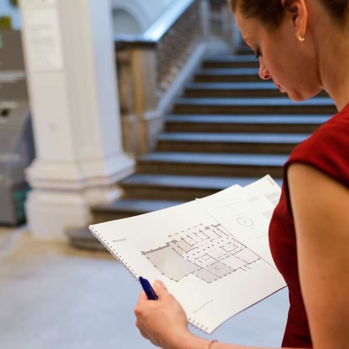 Frau im roten ärmellosen Hemd, das weißes Druckerpapier hält Schiebepuzzle online