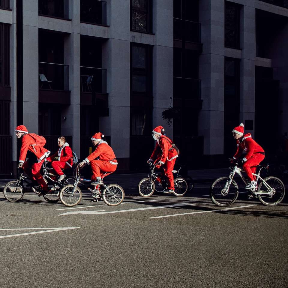 grupp människor som bär jultomten kostym ridning cyklar Pussel online