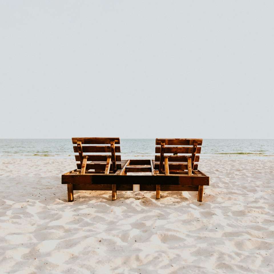 duas cadeiras de praia na areia perto do oceano puzzle online