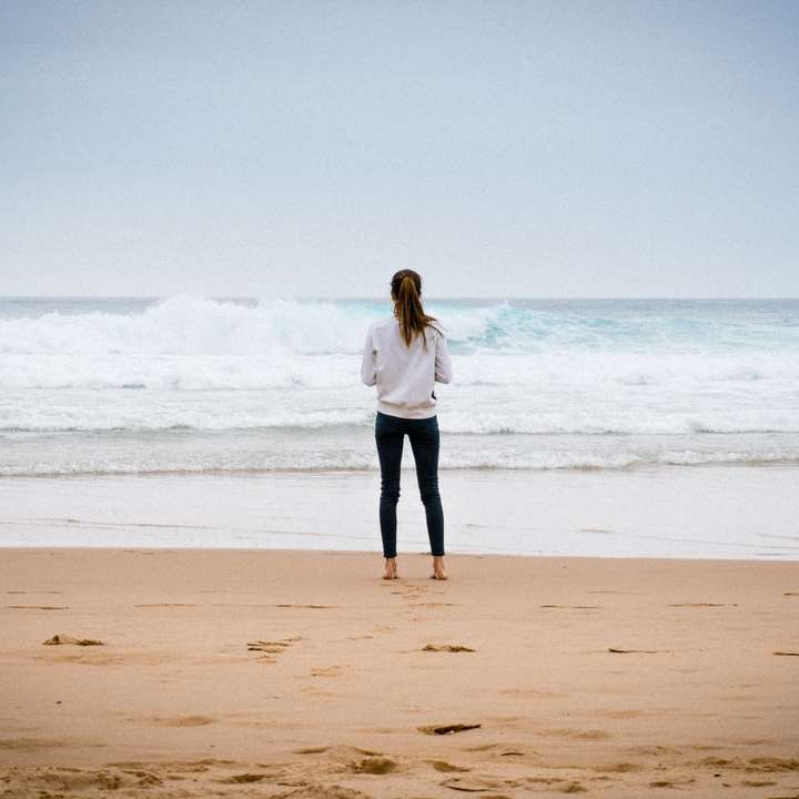 жена, стояща близо до морския бряг през деня плъзгащ се пъзел онлайн