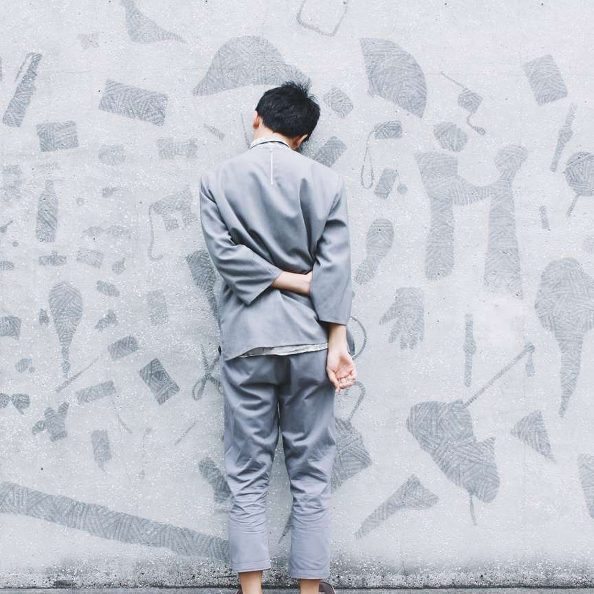 Човек се облегна на сива стена онлайн пъзел