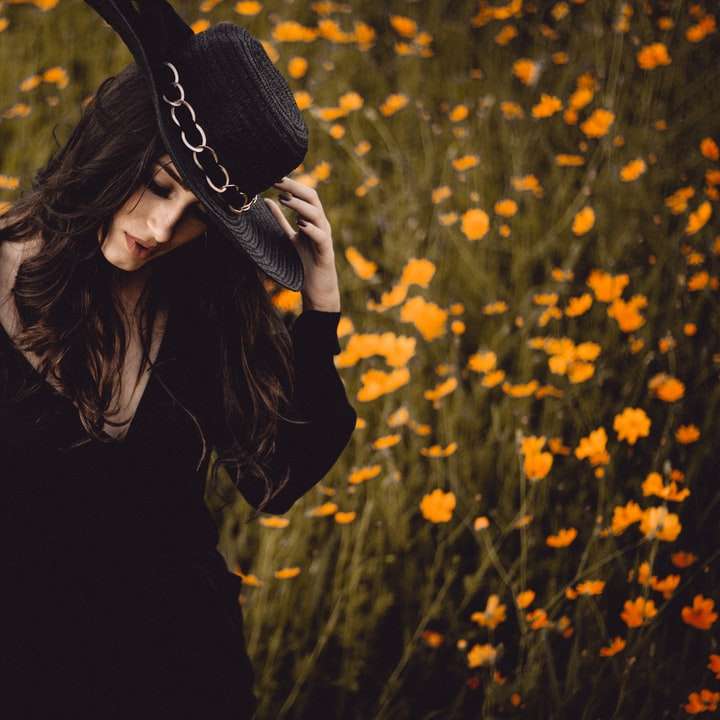 Kobieta w czerni w kwiatu polu puzzle online