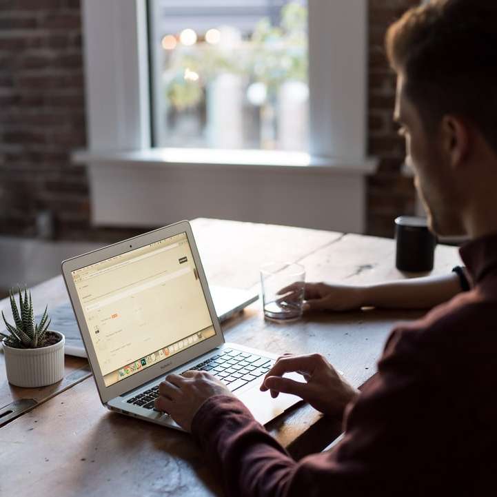 Man op een laptop in een kantoor schuifpuzzel online