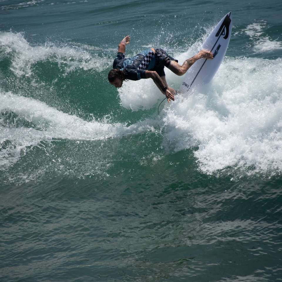 mężczyzna jedzie na desce surfingowej na morzu puzzle przesuwne online