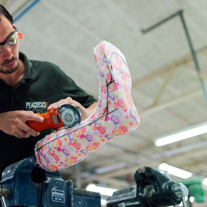 Un ingénieur technicien orthésiste masculin fait un plâtre de jambe personnalisé puzzle coulissant en ligne