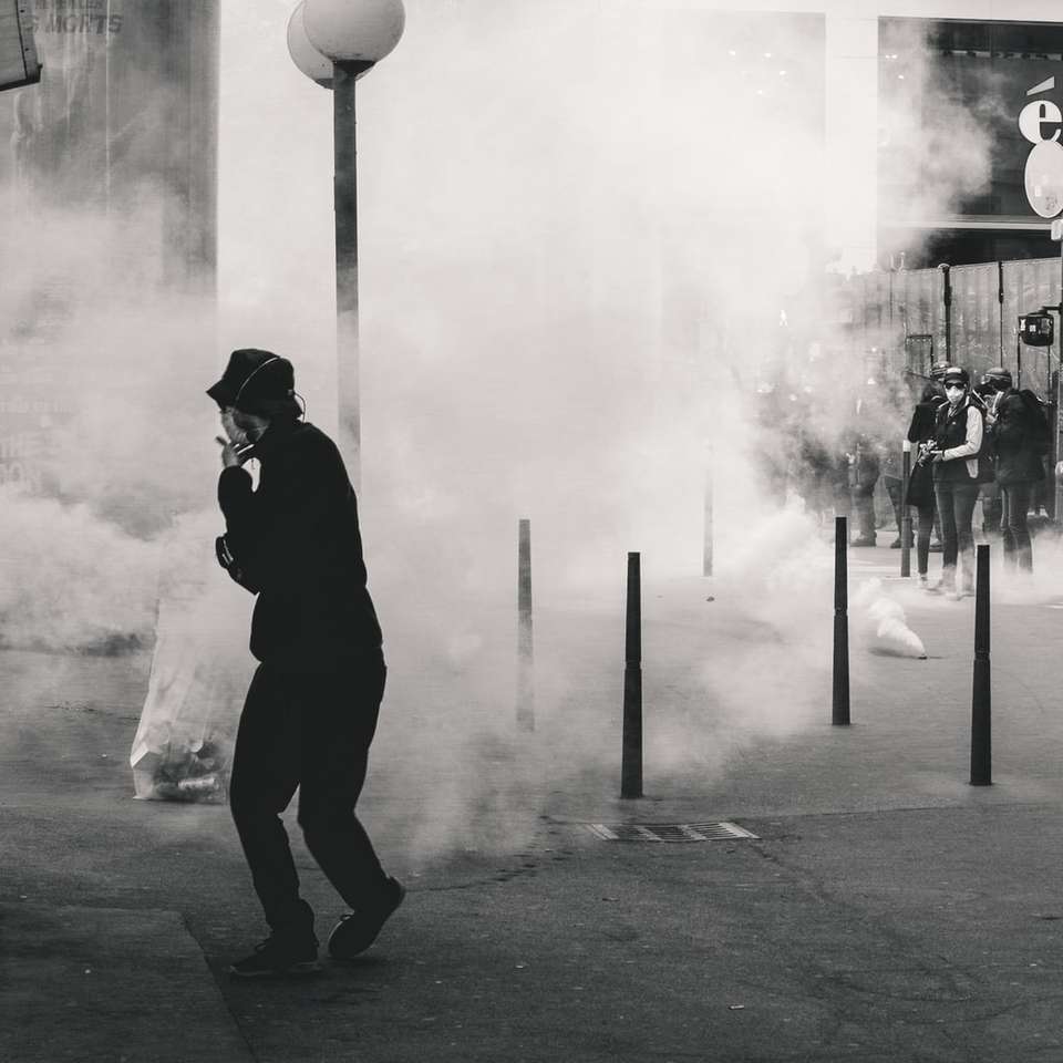 Фотография человека возле дыма в оттенках серого онлайн-пазл