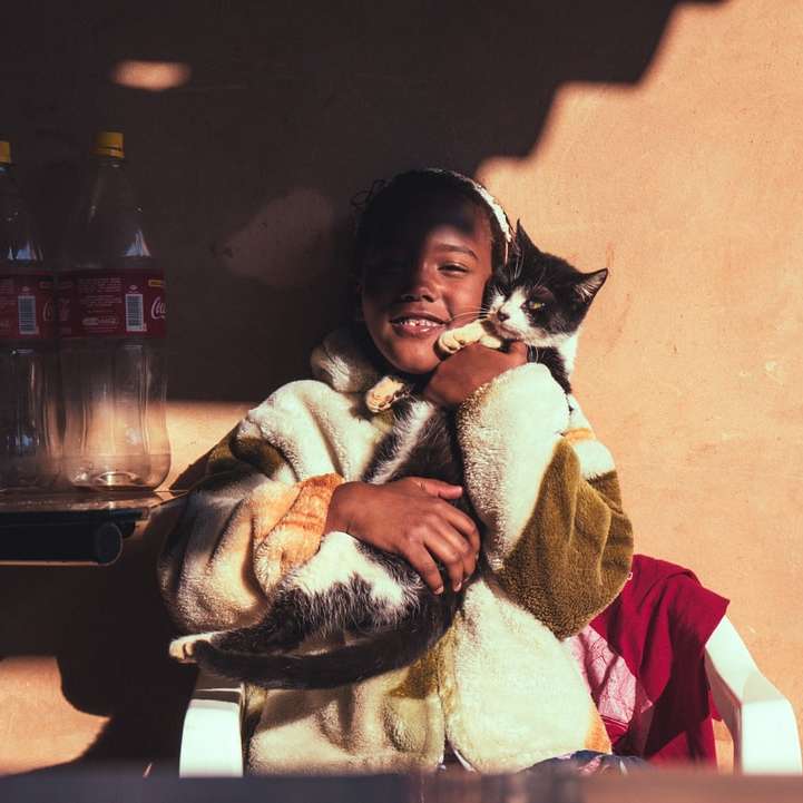 Νέο κορίτσι που αγκαλιάζει μια γάτα συρόμενο παζλ online