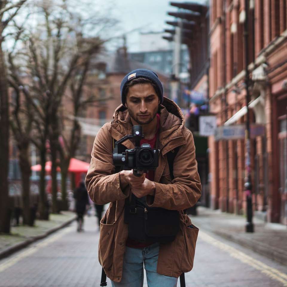дълбочина на полевата фотография на човек, който държи камера онлайн пъзел