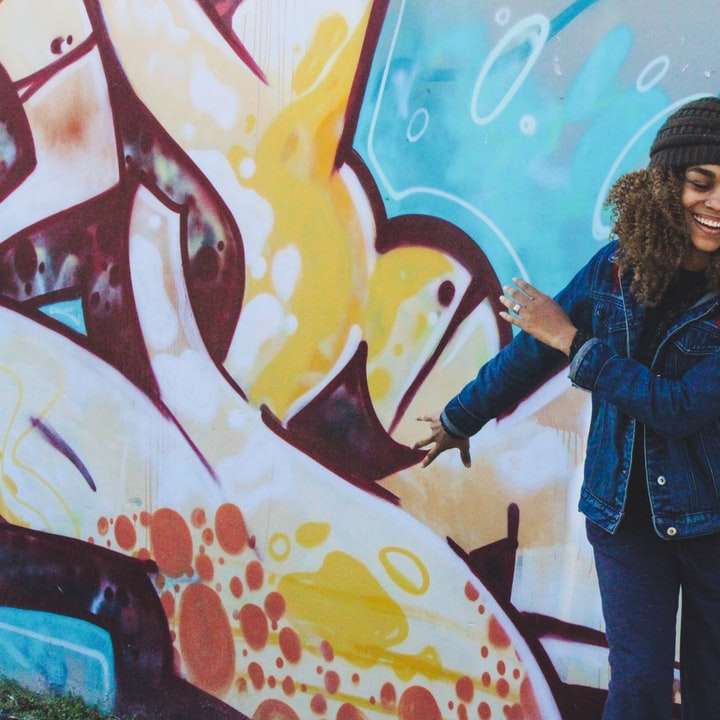 Mujer sonriendo delante de graffiti rompecabezas en línea