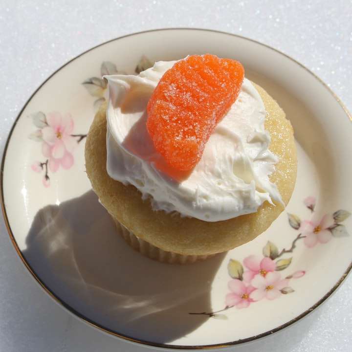 Cupcake mit Orangenbonbon auf Blumenteller Online-Puzzle