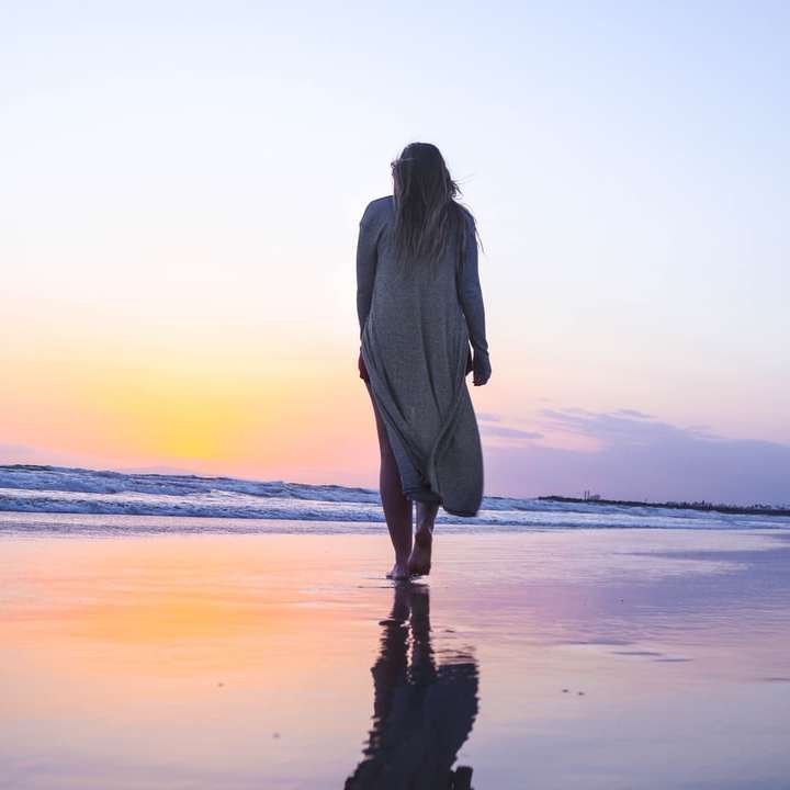 Donna che cammina sulla spiaggia di sabbia puzzle online
