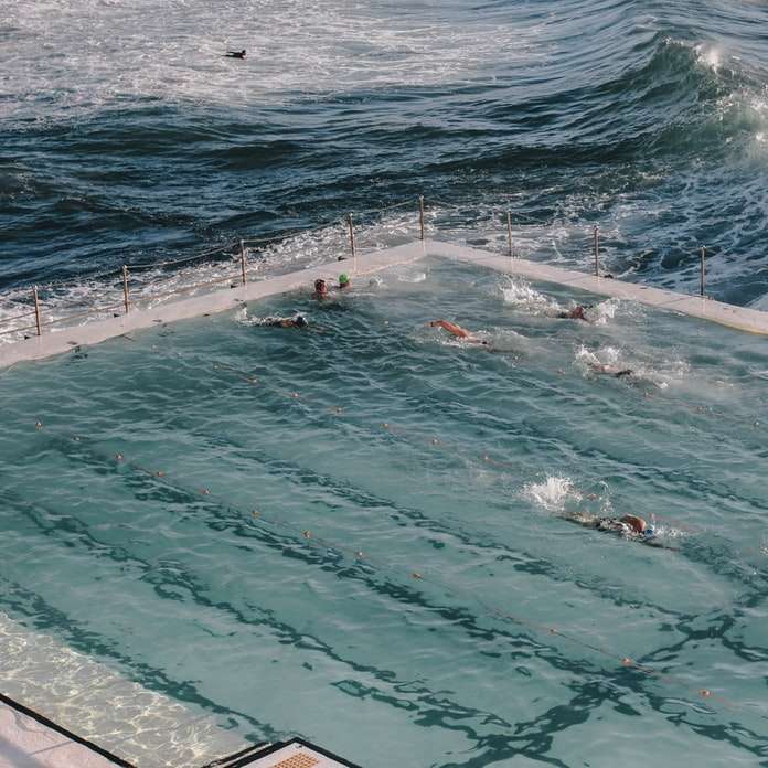 άτομα που κολυμπούν στην παραλία κατά τη διάρκεια της ημέρας online παζλ