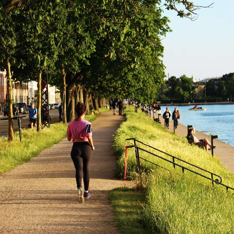 woman jogging near body of water sliding puzzle online