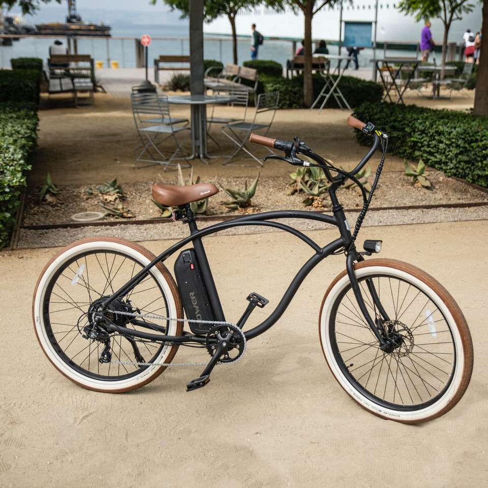 Uma bicicleta elétrica da torre na praia. puzzle online