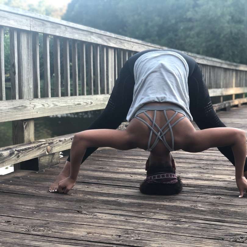 Prasarita Padmottanasana Yoga poserar på en bro. Foto av Christina Mills. glidande pussel online