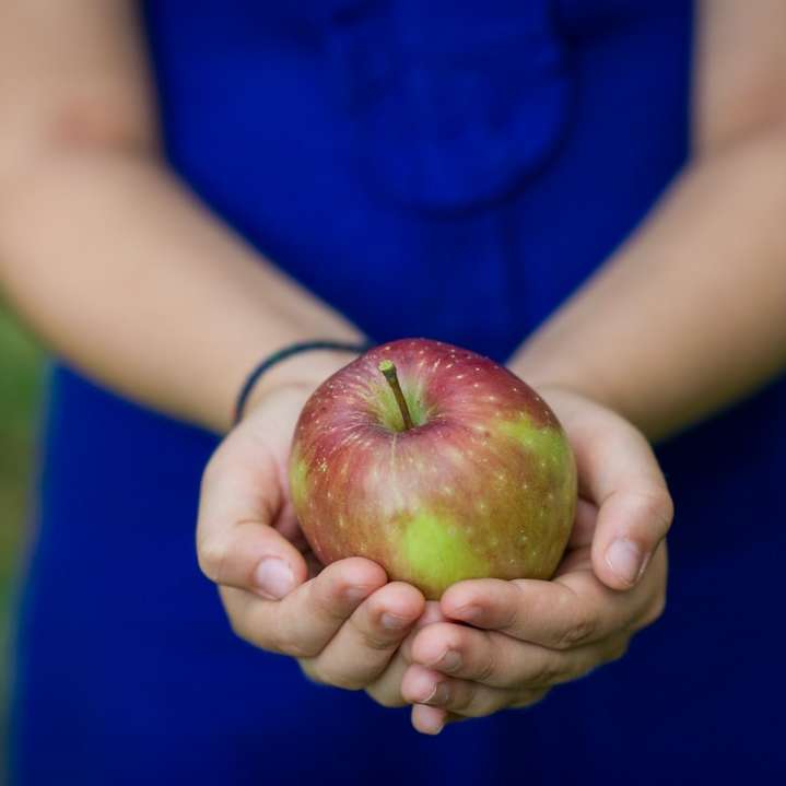 човек, който държи плодове от зелена ябълка онлайн пъзел