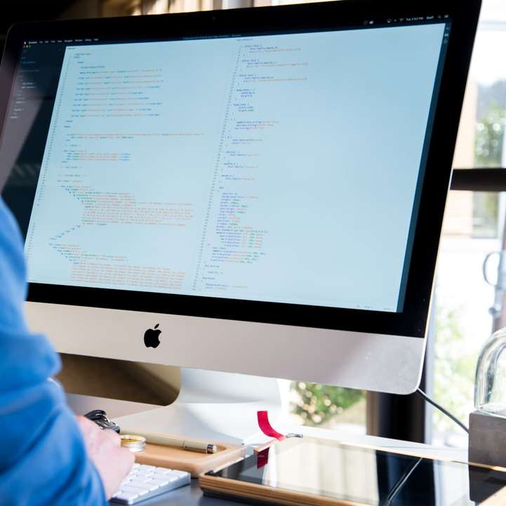 Разработчик, работещ върху iMac плъзгащ се пъзел онлайн
