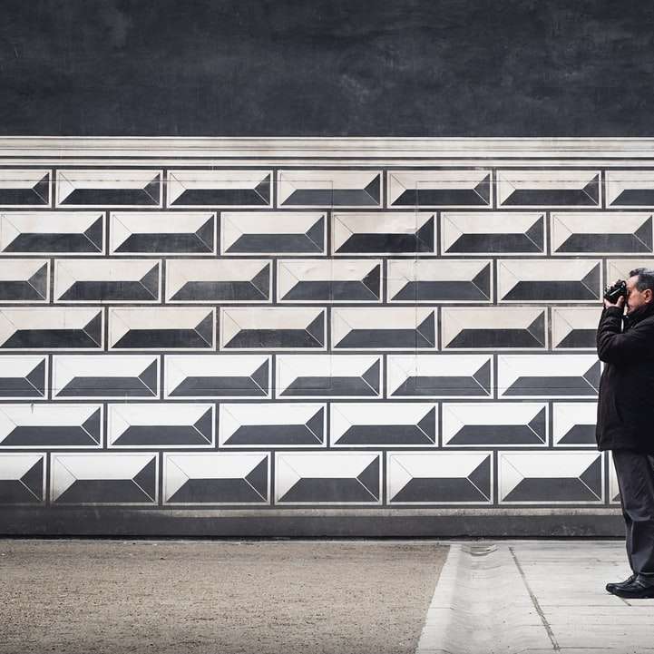 mężczyzna trzyma aparat w pobliżu ściany puzzle online