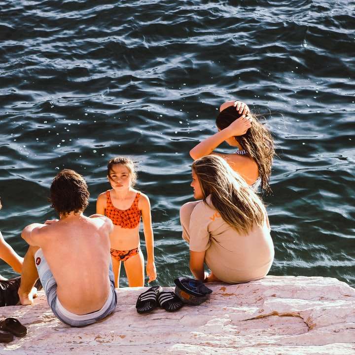 grupo de crianças conversando perto do corpo de água puzzle deslizante online
