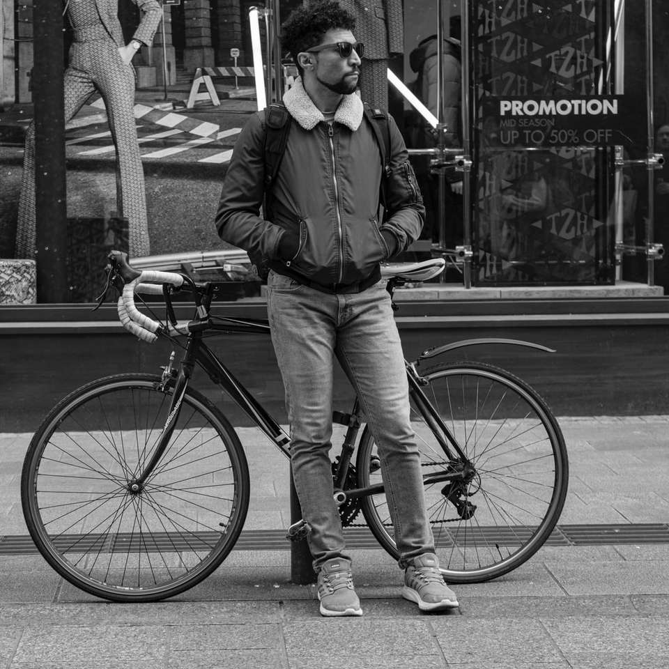 мъж, облегнат на кряк в близост до велосипед плъзгащ се пъзел онлайн