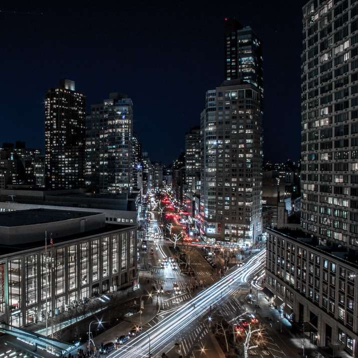Fotografía de lapso de tiempo de vehículos cerca de edificios de gran altura durante la noche puzzle deslizante online
