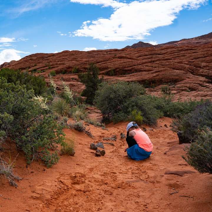 kobieta kolano w pobliżu wzgórza i krzewów w ciągu dnia puzzle online