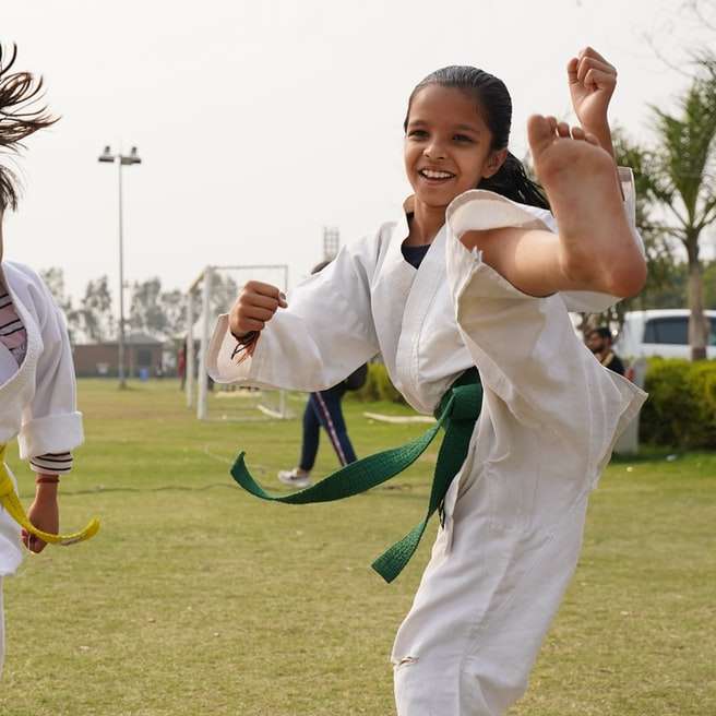 Unga flickor som tränar och undervisar kampsport till studenter glidande pussel online