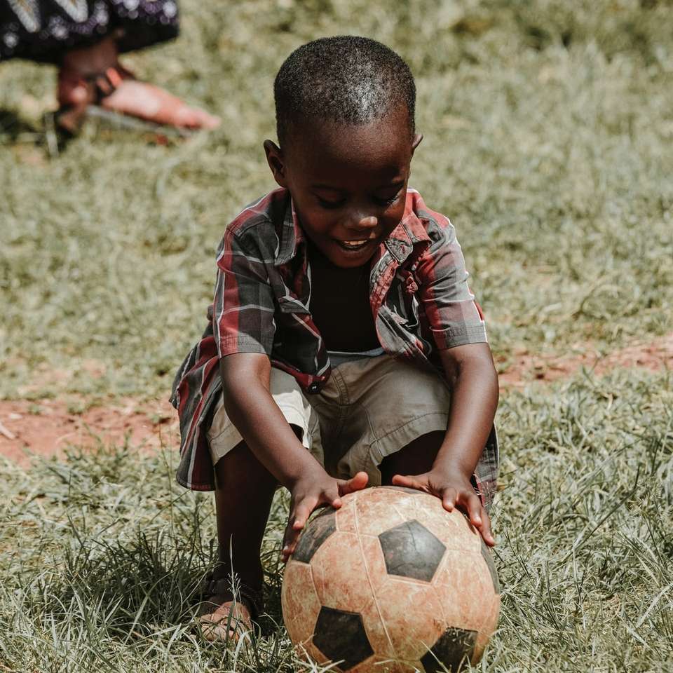 Ребенок улыбается с футбольным мячом онлайн-пазл