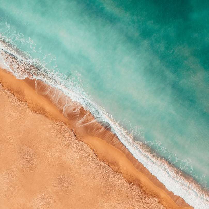 Vinklade havsvågor med sandstrand glidande pussel online