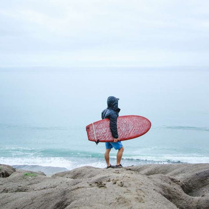 osoba, která drží surfovací prkno online puzzle