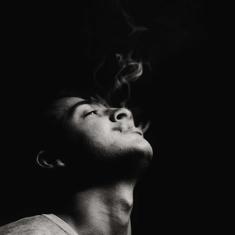 fotografia em escala de cinza do homem fumando puzzle deslizante online