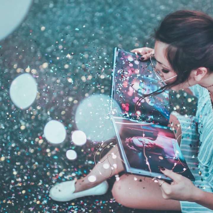 Menina lê um livro de fotos mágico com glitter puzzle online