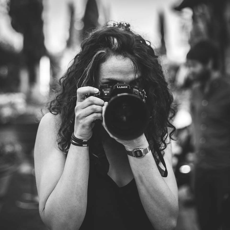 жена държи камера Lumix плъзгащ се пъзел онлайн