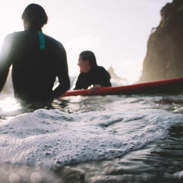 Relaksujący surferzy na plaży Piha puzzle przesuwne online