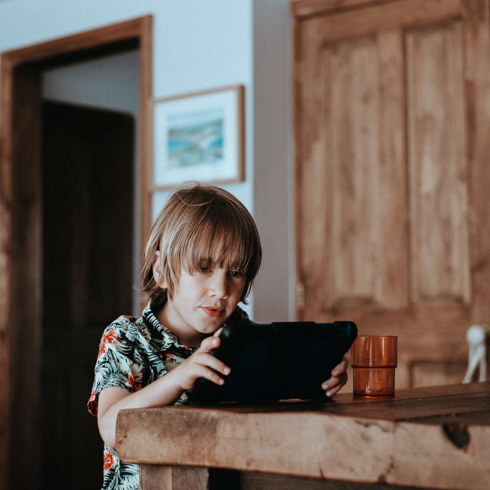 Niño jugando en iPad rompecabezas en línea