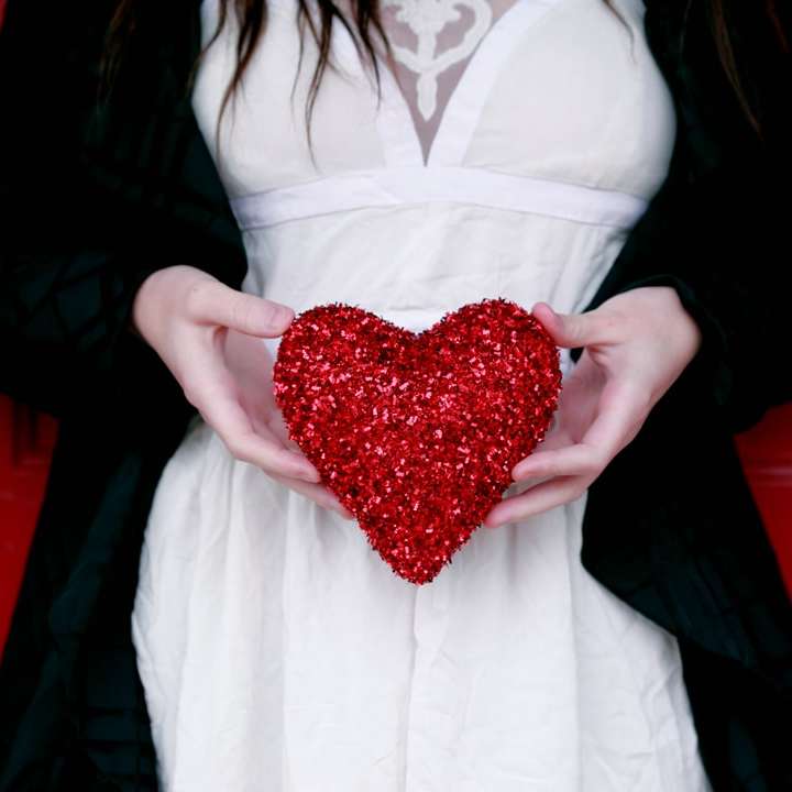 vrouwen die rood harthoofdkussen houden online puzzel