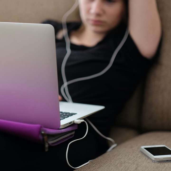 Mulher com um MacBook em um sofá puzzle online