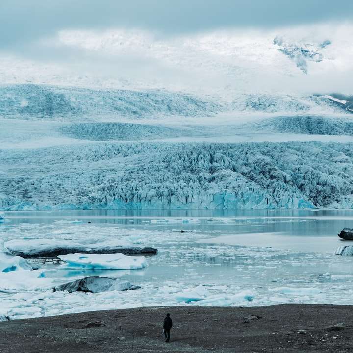 osoba stojící vedle zasněžené pláně a zamrzlé jezero posuvné puzzle online
