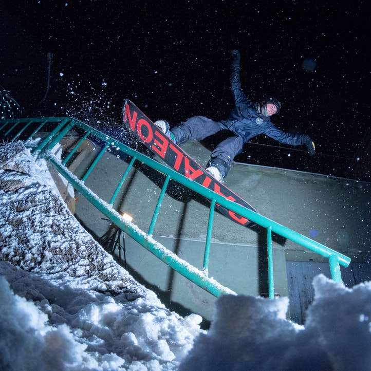 homem andando de snowboard à noite puzzle deslizante online