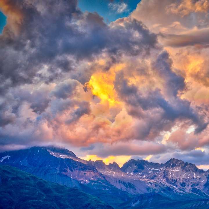 foto av bergskedjan under gyllene himlen Pussel online