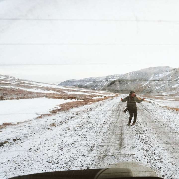 mulher em pé na estrada coberta de neve puzzle online