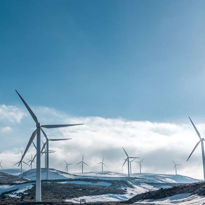 Windturbinen auf schneebedecktem Berg unter klarem blauem Himmel Online-Puzzle