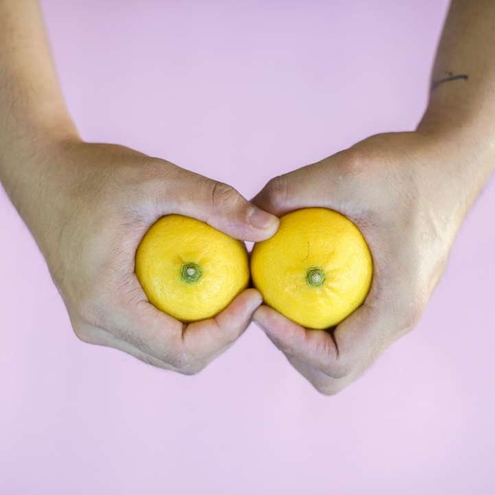 лице, което държи 3 жълти цитрусови плодове онлайн пъзел