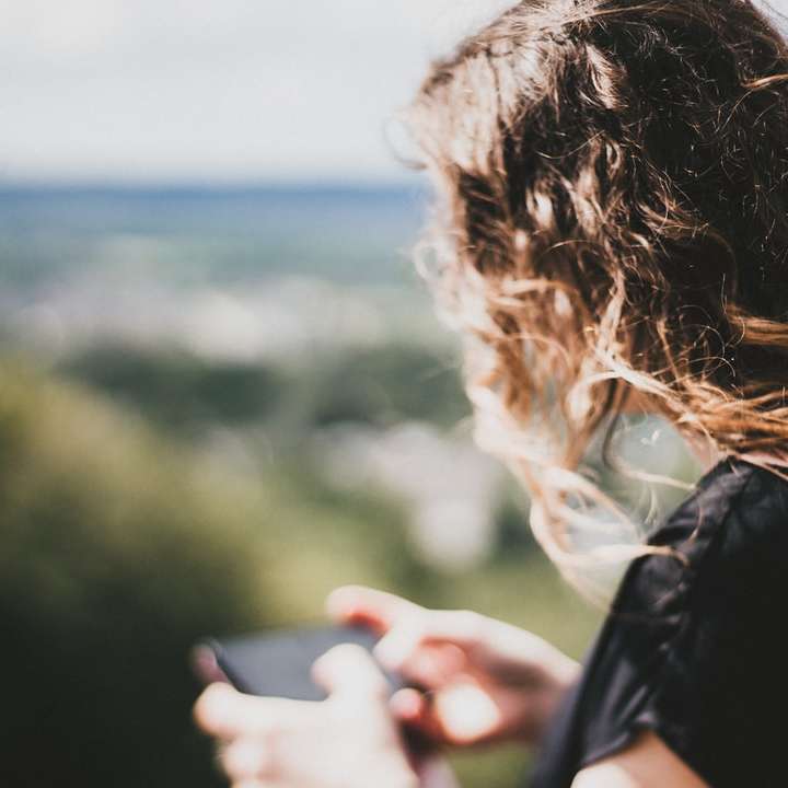 Kobieta patrząc na telefon komórkowy puzzle przesuwne online