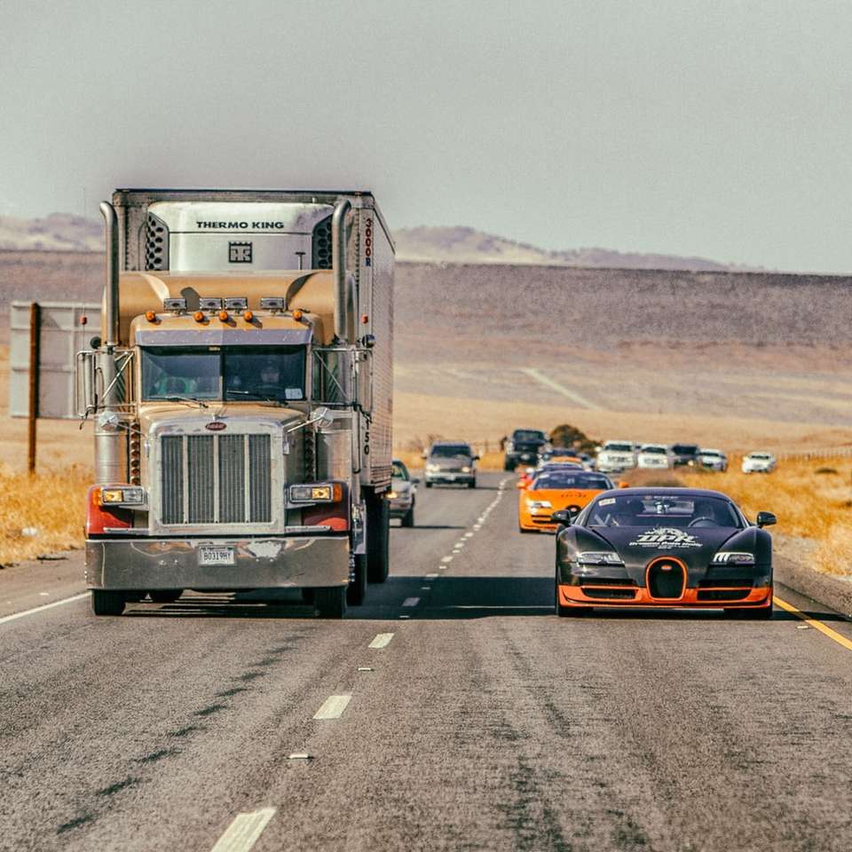 Chevrolet Camaro preto e laranja na estrada durante o dia puzzle online