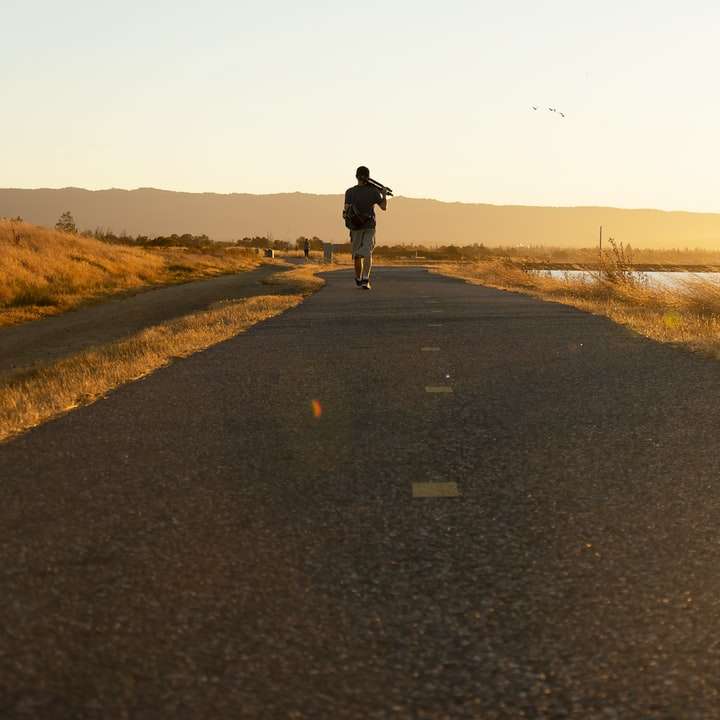Człowiek idący na rozprawie przed zachodem słońca. puzzle online