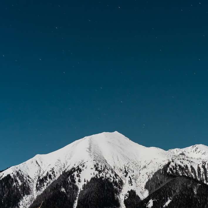 munte acoperit de zăpadă sub cer albastru în timpul zilei alunecare puzzle online