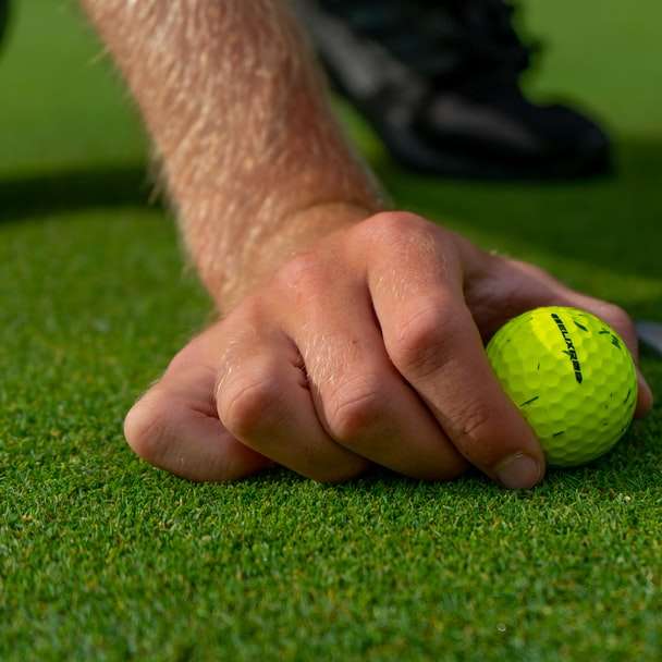 πρόσωπο που κρατάει κίτρινη μπάλα του γκολφ online παζλ